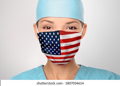 USA American doctor wearing Coronavirus pandemic COVID-19 mask in the United States of America. American flag print on Asian woman doctor's mask smiling in confidence giving hope .
