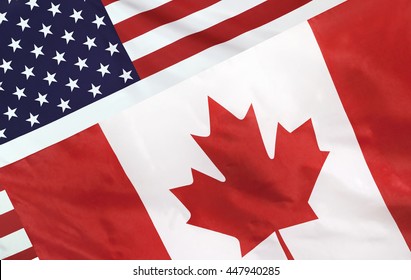 USA and Canada relations concept with diagonally merged real fabric flags