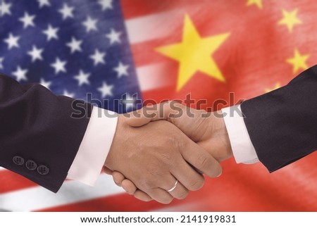 USA and China bilateral political relations and cooperation concept with American flag and Chinese flag painted on handshake.