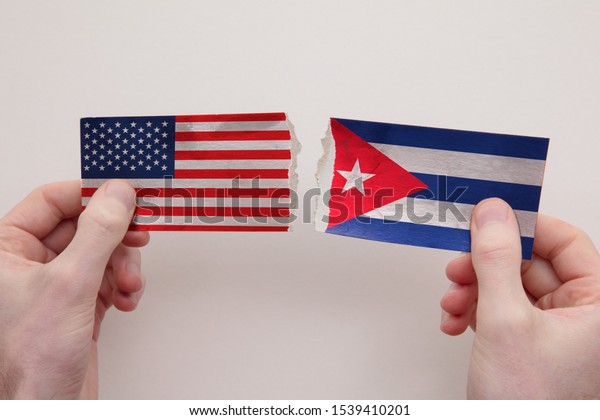 USA and Cuba paper flags ripped apart. political\
relationship concept