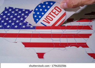 USA Elections 2020, The Hand Of A Man Putting His Vote In A Ballot Box With The US Map And Flag.