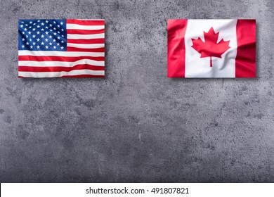 USA flag and Canada flag on concrete background.