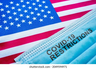 USA flag and face mask with covid 19 restrictions sign. - Shutterstock ID 2049594971