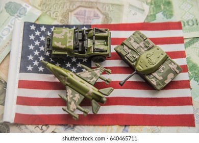 USA Flag Image Photo With A Combat Plane, Khaki Green Tank And Military Car Standing On American Flag And Money Bills.  Withdrawal Of Troops From Afghanistan