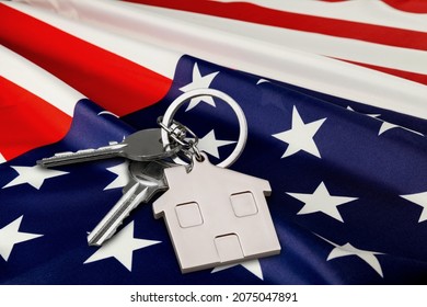 USA Flag And Key From Home As Symbol Of VA Loan On The Desk.