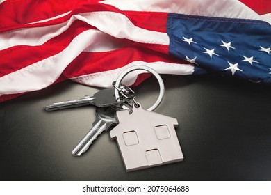 USA Flag And Key From Home As Symbol Of VA Loan On The Desk.