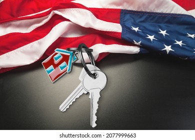 USA Flag And Key From Home As Symbol Of VA Loan On The Desk.