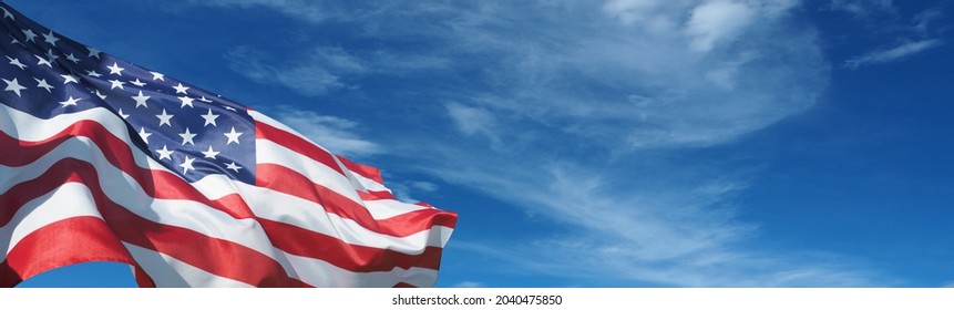 USA flag on a background of blue sky. National holidays concept - Shutterstock ID 2040475850