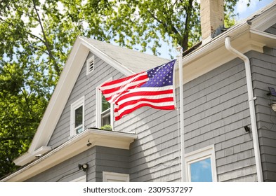 USA flag outside house on July Fourth and Memorial Day symbolizes patriotism, pride, unity, and remembrance of American values - Powered by Shutterstock