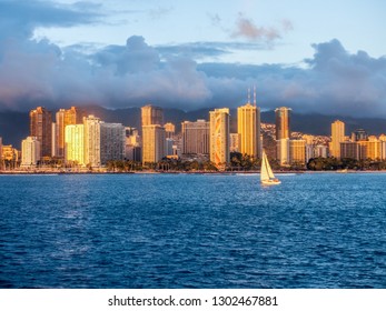 USA, HAWAII - AUGUST 31, 2018: Yacht sailing at sunset with Waikiki skyline in background