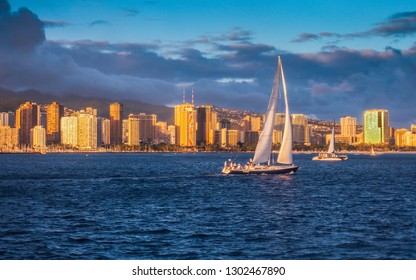 USA, HAWAII - AUGUST 31, 2018: Yacht sailing at sunset with Waikiki skyline in background