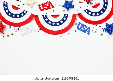 USA Holiday Celebration Concept. American Flag Colors Garland And USA Decorations On White Background. Flat Lay, Top View.