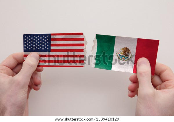 USA and Mexico paper flags ripped apart.\
political relationship\
concept