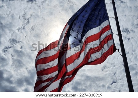 USA national flag waving on wind against blue sky. American stars and stripes spangled banner as symbol of democracy