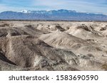 USA, Nevada, Clark County, Tule Fossil Beds National Monument: White gypsum hills at the urban fringe along the Las Vegas Wash with Mt. Charleston in the distance.
