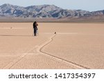 USA, Nevada, Death valley national park: the traveler photographs the famous moving rocks on the Racetrack playa.  