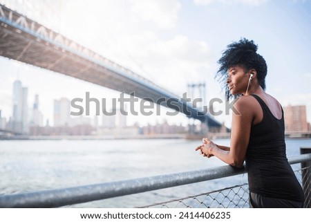 Usa- new york city- brooklyn- woman listening to music near manhattan bridge