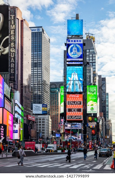 USA, New York, Times Square. May 3, 2019. High\
modern buildings, colorful neon lights, large commercial ads, cars\
and people in a spring day