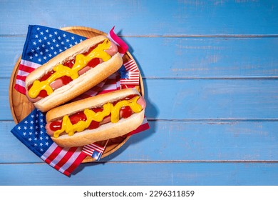 USA Patriotic picnic holiday hot dogs.  American patriotic hot dog on wooden board plate, with USA flag. Celebrating Independence day on 4th July, Memorial or Veteran Day - Powered by Shutterstock