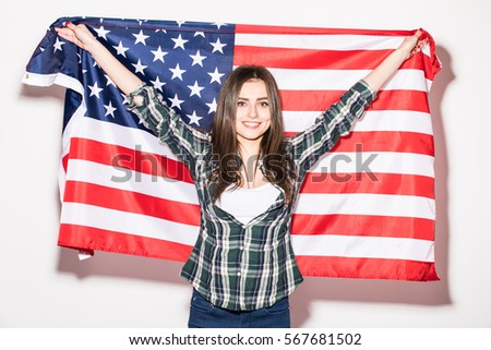 USA patriotism. Young woman with US Flag in hands on white back.