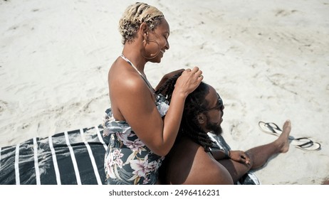 USA, Smiling woman doing mans hair on beach - Powered by Shutterstock