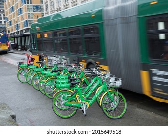 Usa, Washington State, King County, Seattle, Parked Group Of Lime Rental Bikes And Moving Bus