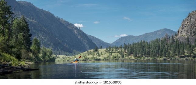 USA, Washington State. A Male Kayaker Paddles A Kayak On A Blue Lake In The Sinlahekin Wildlife Area. Okanagan County.