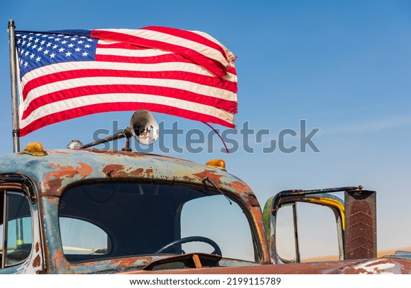 USA, Washington State, Whitman\
County. Palouse. American flag flying on an old rusted\
truck.
