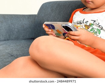 Usage of a smartphone. Smartphone user. Child with smartphone. Entry level gamers. - Powered by Shutterstock