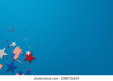 USA's Independence Day celebration depicted with glitter stars, confetti, and national flag. Top view on a blue background with an empty space for text or advertisement