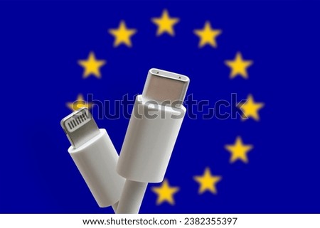 USB C and lightning charging cable on a EU flag background. USB Type C is a universal connector