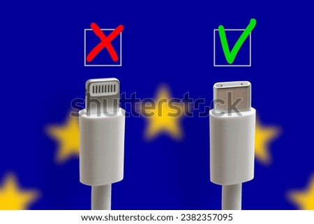 USB C and lightning charging cable on a EU flag background. USB Type C is a universal connector