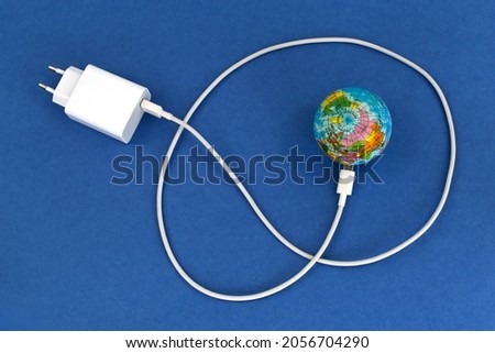 USB cable disconnected from the globe on a blue background. Energy crisis concept. [[stock_photo]] © 