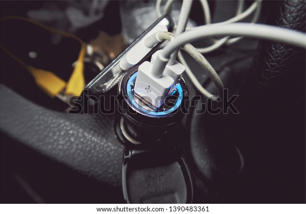 A\
usb car 12 volt usb cigarette lighter charging port in the interior\
of a messy car. Charging phone and digital electronic equipment on\
the move with alternator. 12 volt convertor usb\
socket