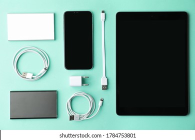 USB charge cables, power adapter and gadgets on light blue background, flat lay. Modern technology - Powered by Shutterstock