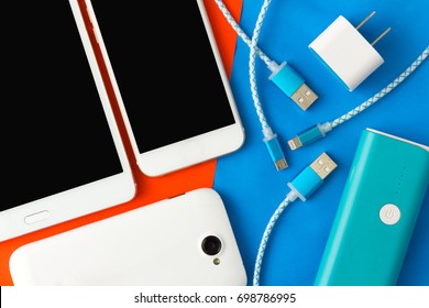 USB charging cables for smartphone and tablet in top view on blue and orange background
