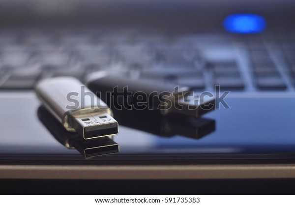USB flash cards\
lying on black laptop case in front of his keyboard. Virtual memory\
storage with USB output
