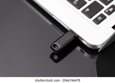 USB flash drive connected to the laptop's USB socket. Pen drive, flash memory concept