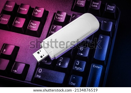 USB flash drive lying on black keyboard. Virtual memory storage with USB output