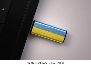 usb flash drive in notebook computer with the national flag of ukraine on gray background. concept