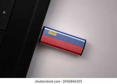 usb flash drive in notebook computer with the national flag of liechtenstein on gray background. concept