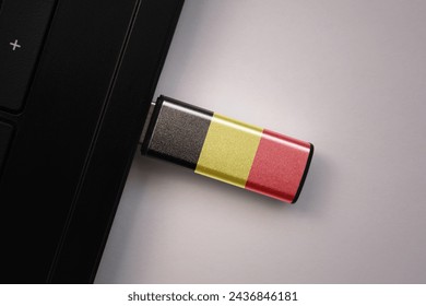 usb flash drive in notebook computer with the national flag of belgium on gray background. concept