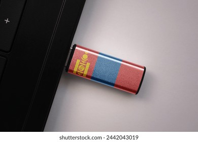 usb flash drive in notebook computer with the national flag of mongolia on gray background. concept