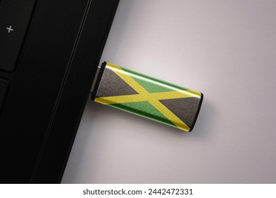 usb flash drive in notebook computer with the national flag of jamaica on gray background. concept