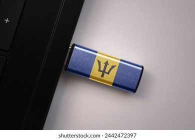 usb flash drive in notebook computer with the national flag of barbados on gray background. concept