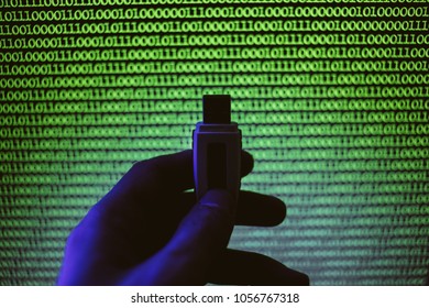 USB flash drive on a background of green binary code. A man holds a USB flash drive on the background of a computer monitor. vintage photo processing
