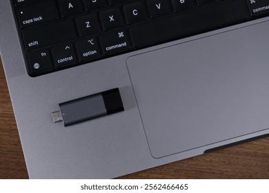 usb flash drive placed on laptop touchpad for file transfer, storage, or backup purposes