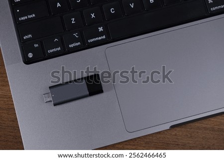 usb flash drive placed on laptop touchpad for file transfer, storage, or backup purposes