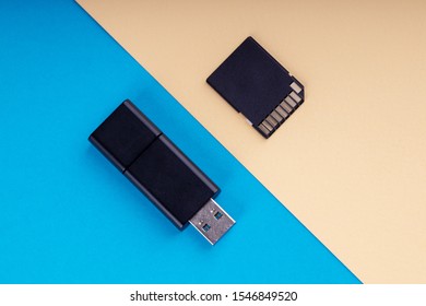 usb flash and sd memory card on blue and yellow background. different kind of portable storage devices. data store concept.