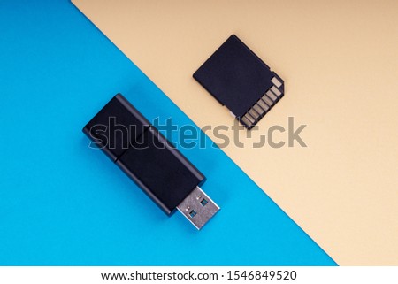usb flash and sd memory card on blue and yellow background. different kind of portable storage devices. data store concept.